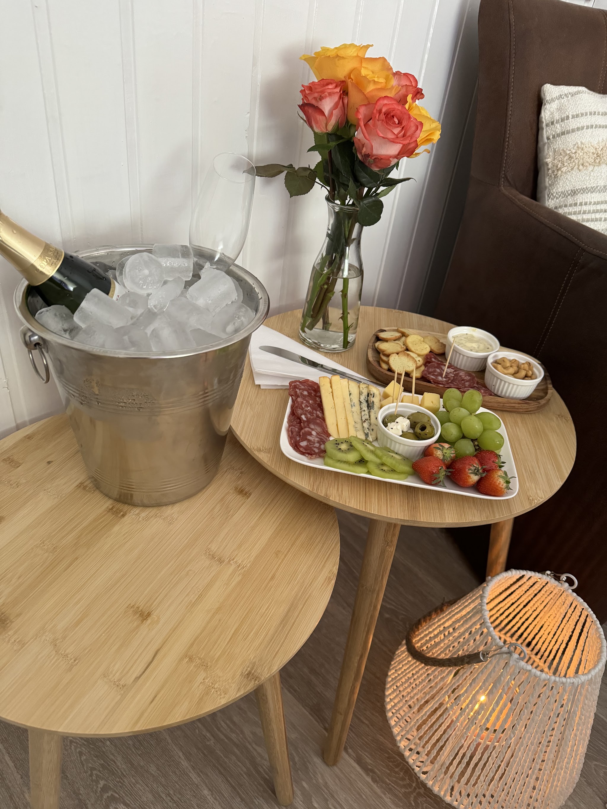 Bubbels in een ijsemmer, rozen en een plankje met kaas en fruit